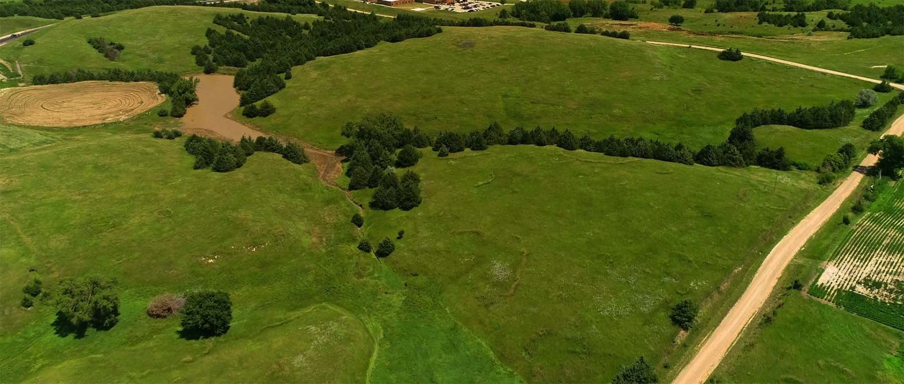 Aerial photograph of pasture land and a pond.